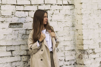 Woman standing against brick wall