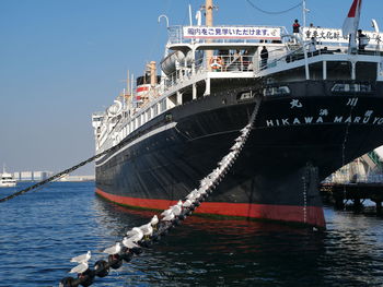 Ship moored at harbor against sky