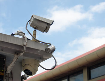 Low angle view of cctv camera  against sky.