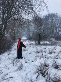 Full length of woman standing on snow covered land