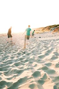 People on beach against clear sky