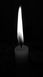 Close-up of illuminated candle against black background