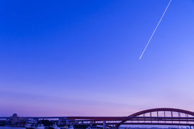 Bridge over sea against clear blue sky