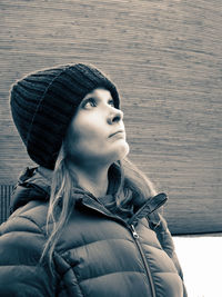 Mid adult woman in warm clothing looking up