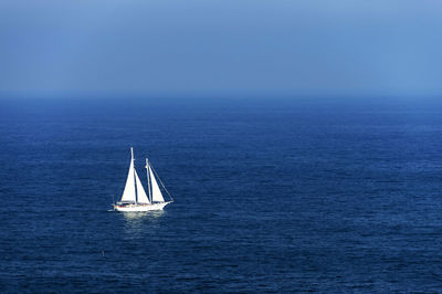 Sailboat sailing on sea against sky