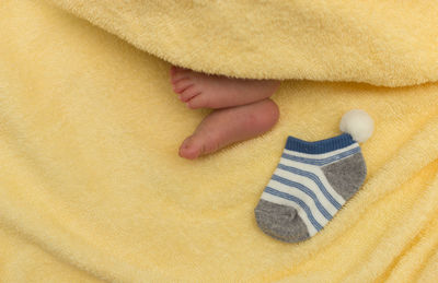 Low section of baby with sock lying on bed