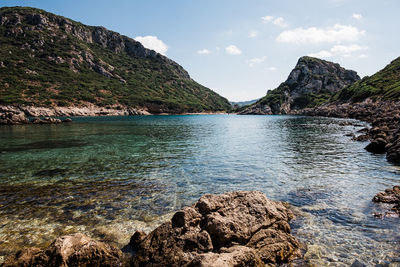 Scenic view of sea and mountains against sky