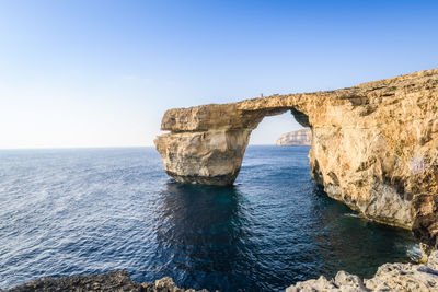 Rock formation at gozo island against clear sky