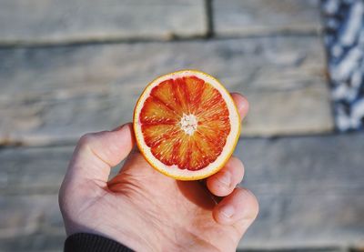 Close-up of hand holding orange