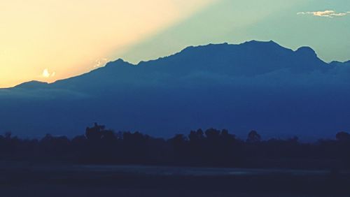 Scenic view of mountains against sky at sunset