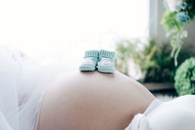 Close-up of baby shoes on belly