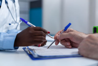 Midsection of doctor examining patient at clinic