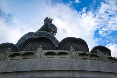 Low angle view of statue against building against sky