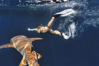 Woman swimming by nurse shark in sea