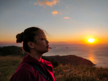 Portrait of man looking away against sky during sunset