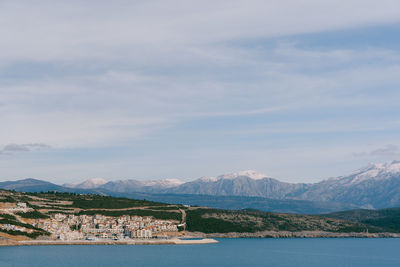 Scenic view of lake by buildings against sky