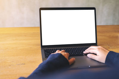 Midsection of man using mobile phone on table