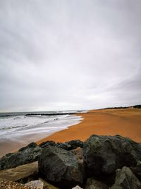 Scenic view of rocks on beach against sky