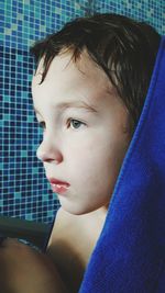 Close-up of boy with blue towel in bathroom