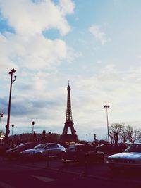 Cars on road against cloudy sky