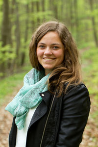 Portrait of smiling woman standing in forest