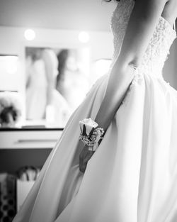 Midsection of bride holding wedding dress