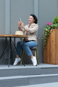 Full length of woman sitting on chair at table