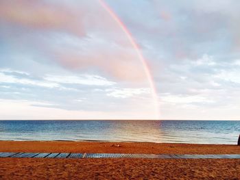 Scenic view of rainbow over sea against sky