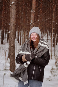 Happy girl in a snowy forest. winter holidays in the forest. smiling girl walking in the woods