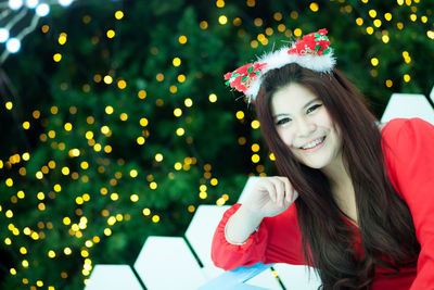 Portrait of smiling woman against christmas decoration