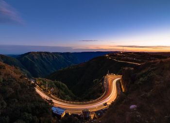 High angle view of light trails on road against sky at sunset