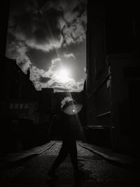 Silhouette people by illuminated light against sky at night
