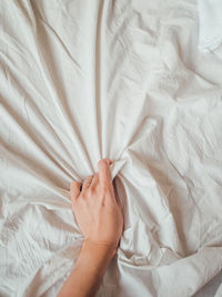 Woman squeezes white linen. cozy imperfect house. non-ideal cozy home.