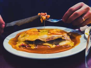 Close-up of hand holding food in plate