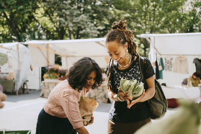 Female customers buying fresh vegetables at flea market