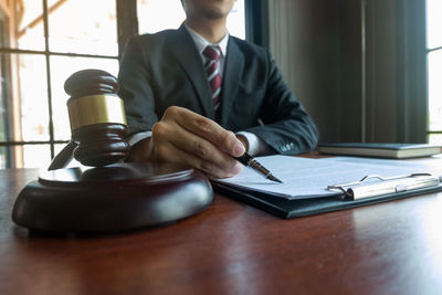 Midsection of man sitting on table