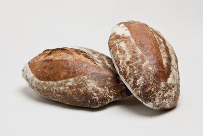 Two loaves of sourdough bread on white background
