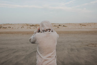 Rear view of horse standing on desert land