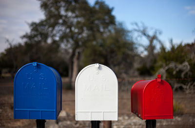 Close-up of mailboxes against trees