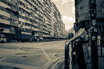 Man in city against sky