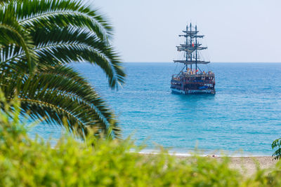 Sailboat in sea against clear blue sky