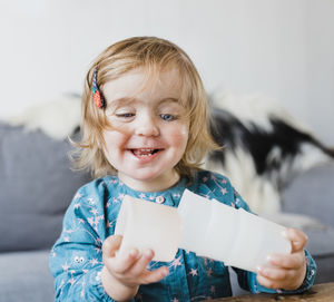 Smiling cute baby girl playing with plastic cups at home