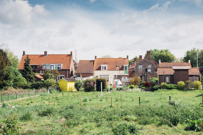 Houses on field against sky