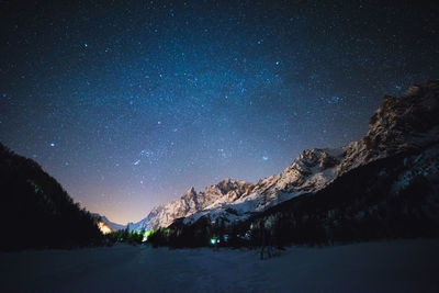 Snowcapped mountains against sky at night