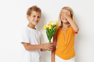 Portrait of brother giving flowers to sister