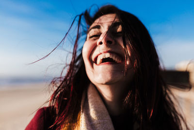 Happy woman having fun at the beach on a windy day at sunset. holidays and fun concept