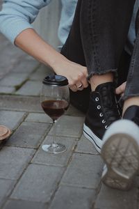 Midsection of man holding wineglass on table