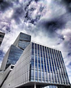 Low angle view of modern building against cloudy sky