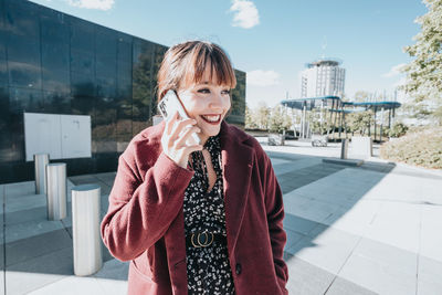 Young woman standing against buildings