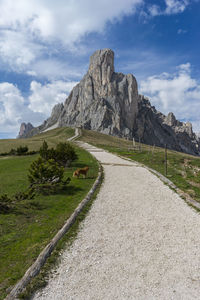 Scenic view of road by mountains against sky